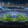 Nighttime stadium concert with a circular stage at the center, fireworks, and a packed crowd surrounding the field.