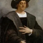Krzysztof Kolumb - NOTE.radio - Polskie radio w UK | Polskie radio w Londynie Portrait of a man in a dark robe and wide black hat, right hand on his chest, looking at the viewer.