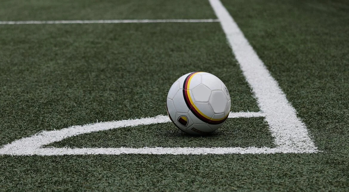 Soccer ball resting on a grassy field near white sideline markings. - Informative and concise option 1.