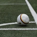 Soccer ball resting on a grassy field near white sideline markings. - Informative and concise option 1.