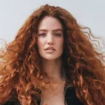 Jess Glynne - NOTE.radio - Polskie radio w UK | Polskie radio w Londynie Portrait of a woman with long, voluminous red curly hair looking at the camera. (informative)