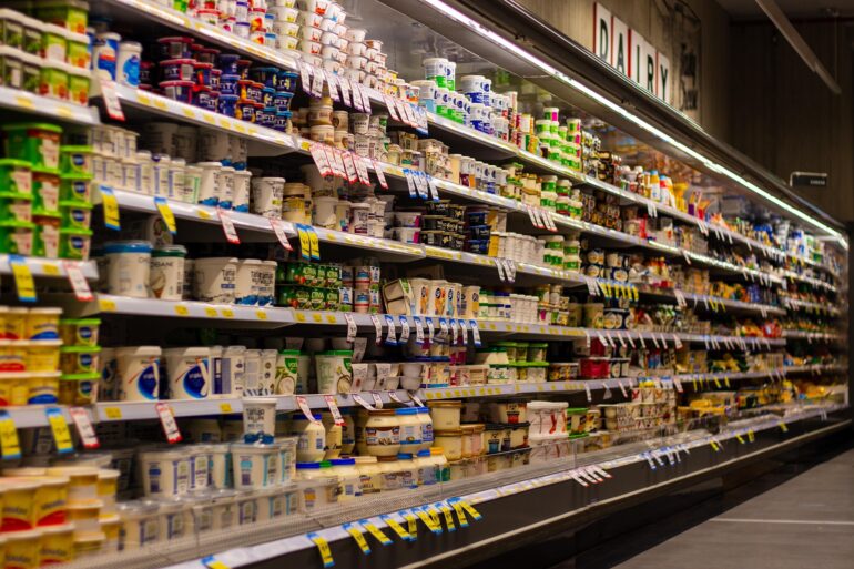 mleko - NOTE.radio - Polskie radio w UK | Polskie radio w Londynie Aisle in a grocery store's refrigerated dairy section filled with yogurt cups and tubs on shelves.