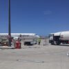 Airlink commuter jet on the tarmac with ground crew and a fuel truck nearby under a clear blue sky