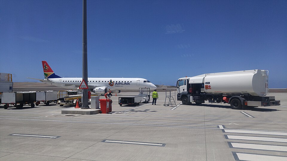 Airlink commuter jet on the tarmac with ground crew and a fuel truck nearby under a clear blue sky