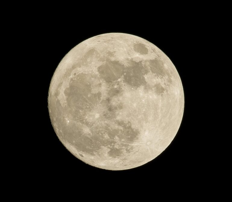 Close-up view of the Moon's cratered surface against a black sky; details of craters and maria visible throughout the disk.