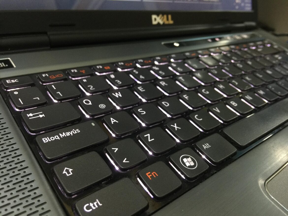 Close-up of a black Dell laptop keyboard, showing Caps Lock (Bloq Mayús), Ctrl, Fn, and Windows keys with subtle backlighting.