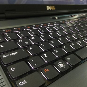 Close-up of a black Dell laptop keyboard, showing Caps Lock (Bloq Mayús), Ctrl, Fn, and Windows keys with subtle backlighting.