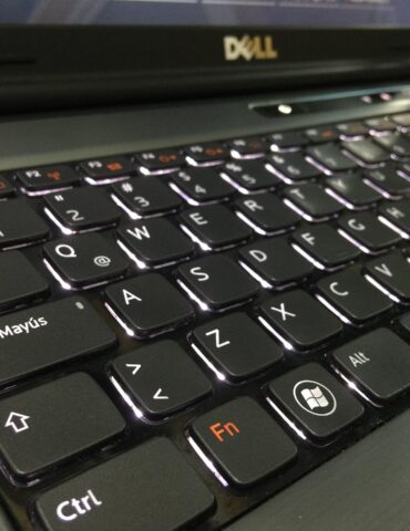 Close-up of a black Dell laptop keyboard, showing Caps Lock (Bloq Mayús), Ctrl, Fn, and Windows keys with subtle backlighting.