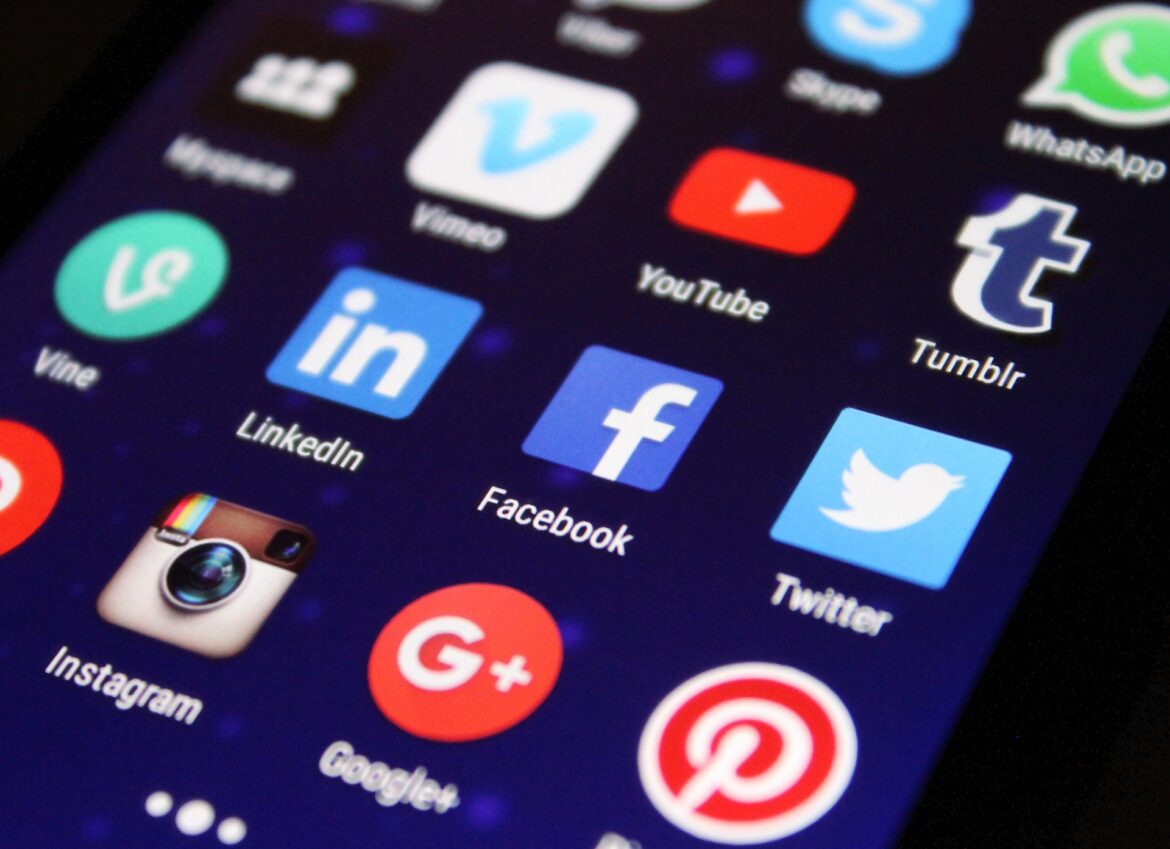 Nastolatek trzymający telefon z aplikacjami social media
