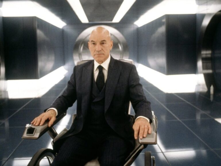 Patrick Stewart jako profesor X - NOTE.radio - Polskie radio w UK | Polskie radio w Londynie Bald man in a dark pinstripe suit sits in a futuristic wheelchair in a shiny sci-fi hallway.