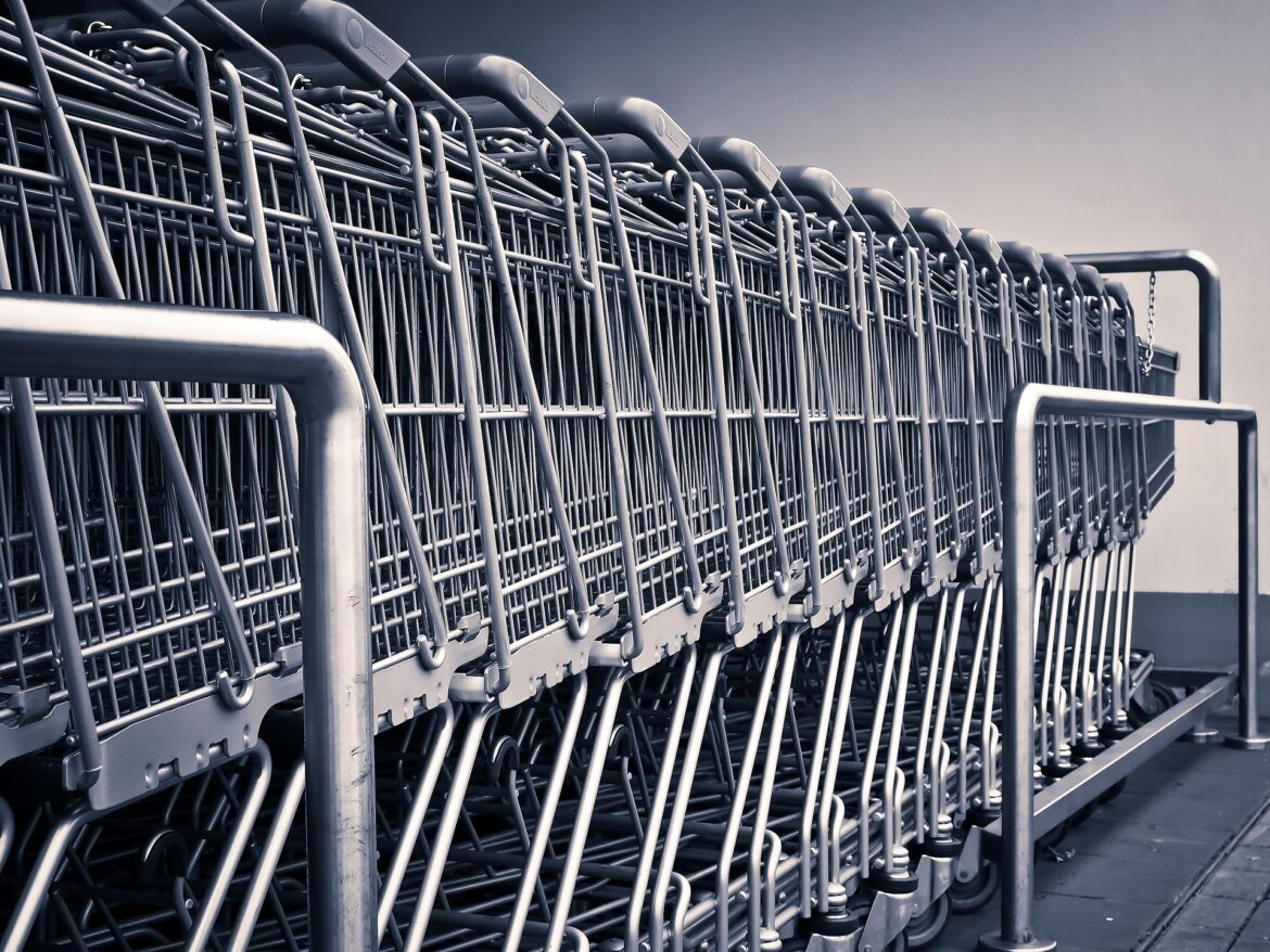 Wózki sklepowe przed supermarketem w Wielkiej Brytanii, symbol możliwej fuzji Sainsbury’s i Morrisons.