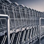 Wózki sklepowe przed supermarketem w Wielkiej Brytanii, symbol możliwej fuzji Sainsbury’s i Morrisons.