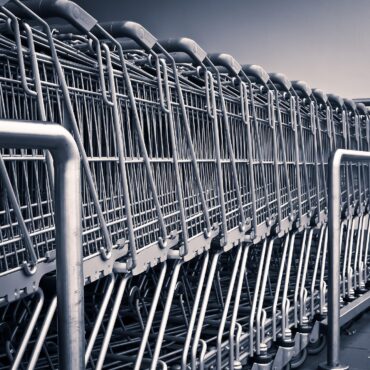 Wózki sklepowe przed supermarketem w Wielkiej Brytanii, symbol możliwej fuzji Sainsbury’s i Morrisons.