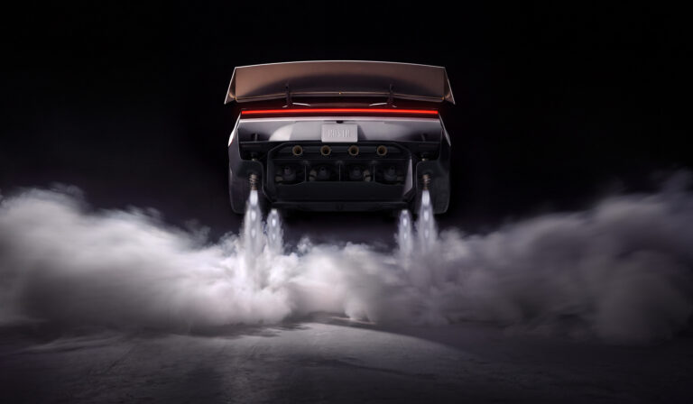 Rear view of a sports car lifting off the ground, exhaust flames and billowing smoke beneath against a dark backdrop