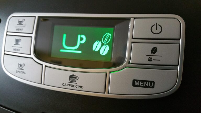 Close-up of a coffee machine control panel with a green LCD showing 'UP' and three coffee bean icons; surrounding buttons include Cappuccino, Menu, Power, and mug icons for beverages.