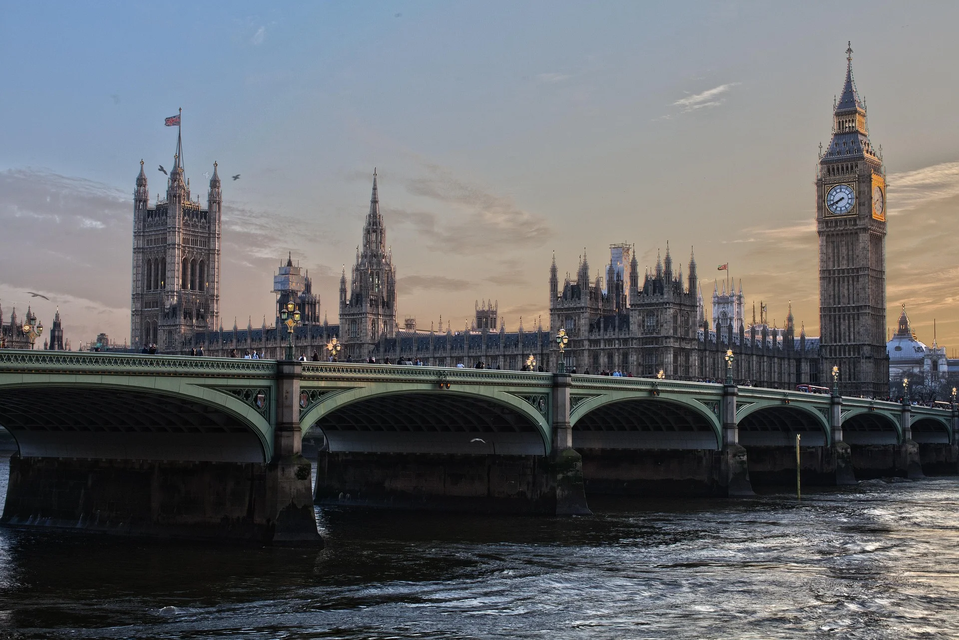 London's Westminster Bridge with the Palace of Westminster and Big Ben at sunset along the Thames.
