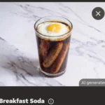Glass of dark breakfast soda with a sunny-side-up egg on top and two sausages inside, on a marble surface.