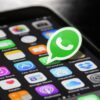 Logo WhatsApp na ekranie telefonu z informacją o nowych opłatach za wybrane wiadomości biznesowe.