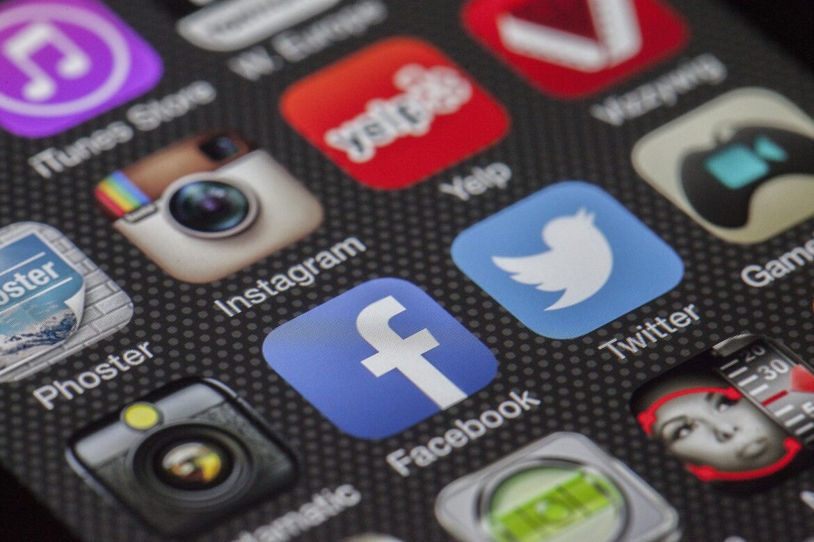 Close-up of a smartphone home screen showing social apps like Instagram, Facebook, and Twitter with colorful icons.