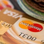 Close-up of a Mastercard credit card on a brown surface with the Mastercard logo visible, though slightly blurred.