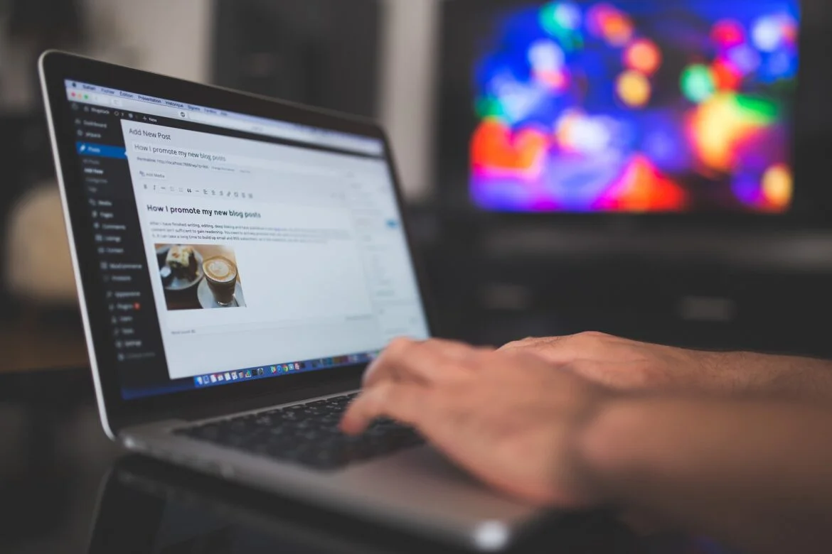 Person typing on a laptop; screen shows a blog post editor with the title 'How I promote my new blog posts'.