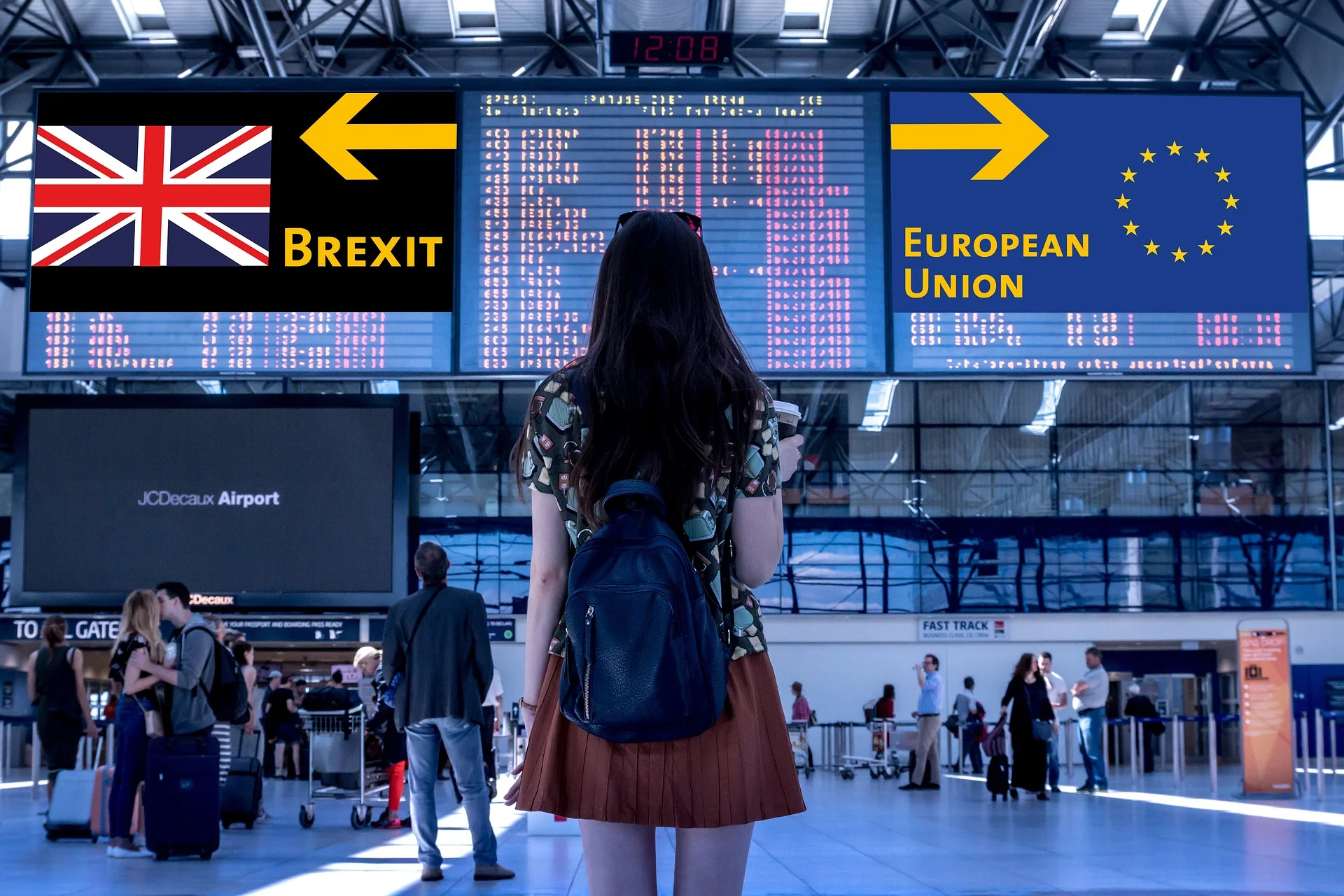 Traveler with backpack stands in an airport terminal, facing large Brexit and European Union signs above a flight information display.