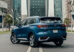 Blue Ford Territory SUV seen from the rear on a city street with tall glass buildings in the background